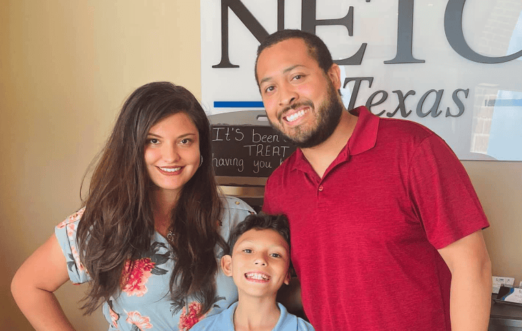 Robert Gibbs in a red shirt, smiling for the camera with his family.